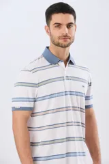 Remera polo de manga corta con diseño a rayas horizontales en tonos azules, celestes, verdes y beiges sobre base azul marino. Presenta cuello camisero con cierre frontal de botones y un pequeño logo bordado en el pecho.
