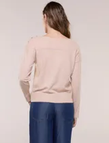 Buzo de punto fino color gris, de calce relajado, escote redondo amplio y canesú con textura acanalada. Cuenta con apliques de tachas metálicas doradas en la línea del hombro, mangas largas de hombro caído y puños y ruedo acanalados.