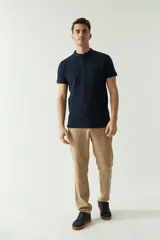 Pantalón de corte regular confeccionado en una mezcla de algodón y lino, con diseño de cinco bolsillos y cierre frontal con botón y cremallera.