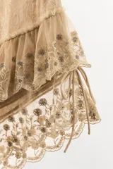 Shorts de tiro medio con cintura elástica, confeccionados en tejido con superposición de volantes, bordados florales y detalles de abalorios. Presenta tiras laterales ajustables con lazada.