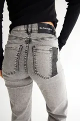 Pantalón de jean azul oscuro, corte oxford con alforza en el delantero y dobladillo en la botamanga.