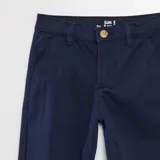 Pantalón chino azul marino, de corte slim, con bolsillos laterales y traseros. Cierre con botón y cremallera.