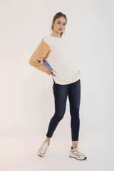 Pantalón de jean corte chupín, color azul oscuro con efecto lavado, de tiro medio y largo al tobillo.