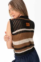 Chaleco tejido a crochet con rayas horizontales en negro, marrón y blanco. Tiene cuello en V y cierre frontal con botones de madera.