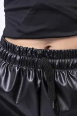 Short negro de cuero sintético, con cintura elástica ajustable con cordón y bolsillos laterales.