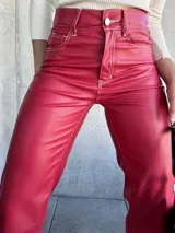 Pantalón de cuero sintético color rojo, de corte recto y tiro alto, con costuras blancas a contraste.