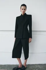 Blazer entallada color negro de ZARA Woman Collection, con escote en pico, manga larga con hombreras, bolsillos con solapa en el delantero y cierre frontal con botones ocultos.