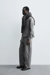 Pantalón de jeans de algodón, color gris oscuro con efecto lavado. De tiro medio y corte relajado con pierna recta desde la cadera hasta el tobillo. Presenta cinco bolsillos y cierre frontal con botonadura.