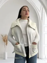 Chaleco blanco con cierre frontal, cuello y bolsillos con textura de piel sintética.