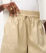 Short runner marrón de sarga con cintura mediana elástica, lazo de ajuste y bolsillos laterales.