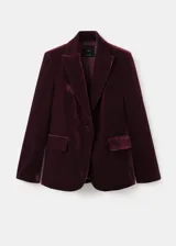 Blazer de terciopelo color bordó, con solapas con muesca, cierre frontal de un botón, bolsillos laterales con solapa y mangas largas con puños abotonados.