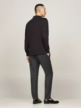 Chomba de manga larga Tommy Hilfiger color negro, confeccionada en algodón. Presenta cuello tipo polo, tapeta de dos botones y logo bordado en el pecho.