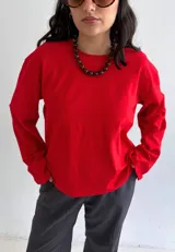 Remera oversize de manga larga color rojo, con cuello redondo y diseño holgado.