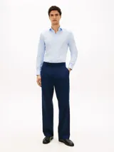 Camisa celeste de corte slim, confeccionada en sarga de mezcla de algodón elástico. Cuenta con cuello italiano, manga larga con puños y cierre frontal con botones.
