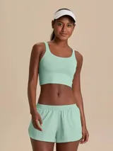 Conjunto deportivo compuesto por una pollera short y un top, ambos en color verde menta. La pollera tipo short cuenta con laterales redondeados, bolsillo en la cintura y short interno con bolsillo lateral. El top presenta diseño clásico con escote redondo y tirantes finos.