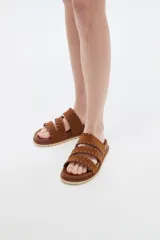 Sandalias planas color negro con tres tiras anchas adornadas con costuras cruzadas en el borde.