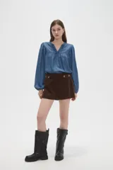 Short de tiro alto confeccionado en pana color marrón, con diseño de botones decorativos en la cintura y corte recto.