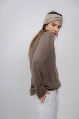 Vincha de lana color beige, tejida a mano, con diseño trenzado en el frente.