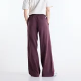 Pantalón de jogging New Balance Trackside holgado de color bordó, confeccionado en felpa francesa de algodón y poliéster. Cuenta con cintura elástica con cordón de ajuste y diseño con bordado y estampado en la pierna izquierda.