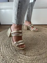Sandalias doradas con plataforma y tacón cuadrado, con tres tiras acolchadas con strass sobre el empeine.