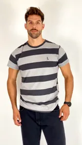 Remera de manga corta con diseño de rayas horizontales en tonos gris y negro, cuello redondo y logo bordado en el pecho.