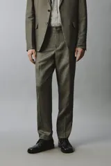 Pantalón de traje regular fit de lino color verde militar, con bolsillos laterales y bolsillos traseros de doble vivo con botón. Cierre frontal con cremallera y botón.
