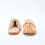 Pantuflas tipo mule color beige, confeccionadas en material efecto gamuza con borde y forro interior de pelo sintético suave.