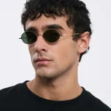 Gafas de sol ovaladas con montura dorada y lentes verdes.