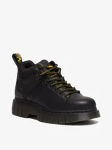 Borcegos Dr. Martens modelo Woodard de cuero negro, con diseño de montaña, cuello acolchado, suela acanalada Club Wedge y cordones estilo excursionista en negro y amarillo.