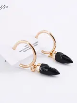 Aros dorados tipo argolla con dije colgante en forma de punta color negro.