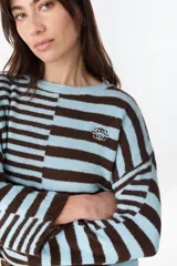 Sweater de punto a rayas horizontales en color chocolate y crudo, con cuello redondo y diseño holgado.