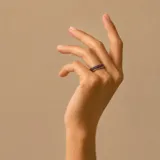 Anillo de diseño elegante elaborado en plata y oro, con una banda central incrustada de circonias pequeñas en tono oscuro.