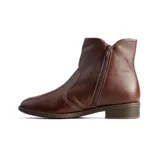 Bota baja de cuero color marrón, con diseño tipo chelsea que incluye paneles elásticos laterales y taco bajo cuadrado.