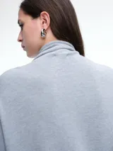 Sweater de cuello polera con hombros caídos y diseño de calce holgado. Presenta terminaciones acanaladas en puños y ruedo, confeccionado en tejido de punto suave.