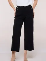 Pantalón crop blanco de corte recto con cintura ancha y botones decorativos laterales. Cuenta con bolsillos y pinzas frontales.