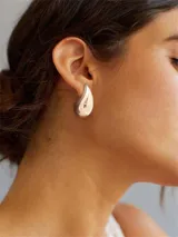 Aros colgantes dorados con forma de gota.