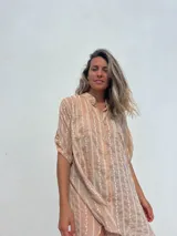 Vestido camisero color beige con bordado vertical en color blanco, de corte recto, cuello mao y mangas cortas con trabilla.