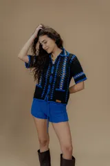 Saco tejido a crochet a mano con detalles en azul y amarillo.