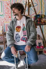 Buzo blanco de corte clásico con cuello redondo y estampado de objetos cotidianos.