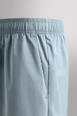 Pantalones deportivos cortos de tejido técnico ligero y elástico, con cintura elástica ajustable, bolsillos frontales y aberturas laterales en el bajo.