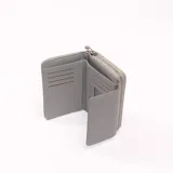 Billetera gris con cierre de cremallera y solapa con broche a presión.