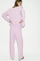 Pantalón de tiro alto color rosado, con pernera recta, bolsillos delanteros y cierre frontal con cremallera, botón interior y gancho.