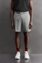 Pantalones cortos de algodón color gris, con cintura elástica ajustable con cordón y parche con logo. Incluye bolsillos laterales y un bolsillo trasero. Presenta bandas laterales a tono, bordado y estampado combinado a contraste en el delantero y la espalda, y aberturas laterales en el bajo.