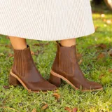 Botas tipo chelsea de cuero vacuno negro, con elásticos laterales, taco cuadrado y punta fina.