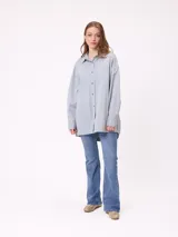 Camisa de manga larga con efecto lavado, corte oversize y cierre frontal con botones. Presenta cuello clásico y logo bordado en el pecho.
