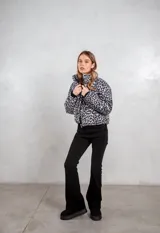 Campera puffer con estampado animal print en tonos gris y negro, cuello alto y cierre frontal.