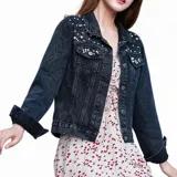 Campera de jean color negro con apliques de perlas en la parte superior frontal. Presenta cuello clásico, cierre frontal con botones metálicos y dos bolsillos en el pecho.