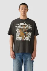 Remera negra de corte holgado con estampado frontal de Woody de Toy Story montando a caballo en un paisaje desértico.