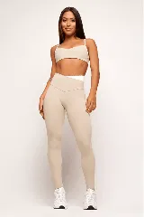 Top deportivo color beige con tirantes finos negros en contraste.