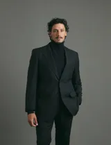 Traje de corte clásico compuesto por saco de dos botones y pantalón de vestir a juego. Diseño tradicional en color negro.